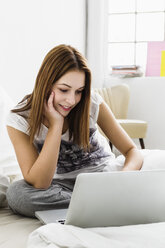 Young woman using laptop, smiling - SPOF000085