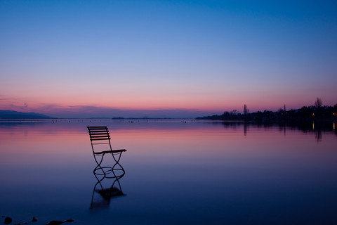 Deutschland, Baden Württemberg, Stuhl am Bodensee im Sonnenuntergang, lizenzfreies Stockfoto