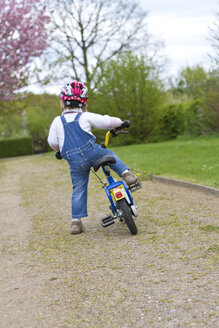 Mädchen mit Helm fährt Fahrrad - JFEF000049