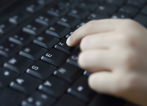 Austria, Human hand writing sex on keyboard, close up stock photo