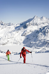 Österreich, Männer beim Skifahren am Berg im Salzburger Land - RN001174