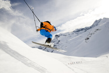 Österreich, Mann springt mit Ski auf Berg - RN001182