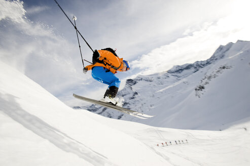 Austria, Man jumping with ski on mountain - RN001182