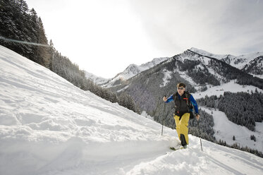 Austria, Man skiing on mountain at Alpbachtal - RN001159