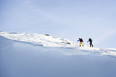 Austria, Men skiing on mountain at Alpbachtal - RN001163