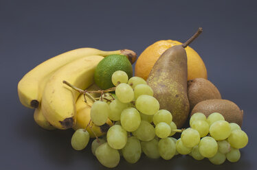 Diverse Früchte auf grauem Hintergrund, Nahaufnahme - MHF000140