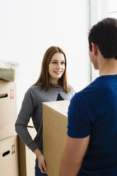 Germany, Munich, Young couple holding cardboard box, smiling - SPOF000236