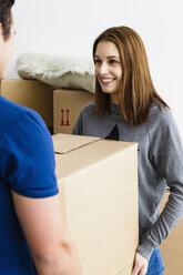 Germany, Munich, Young couple holding cardboard box, smiling - SPOF000237