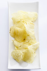 Gesalzene Kartoffelchips auf einem Teller, Nahaufnahme - CSF017834