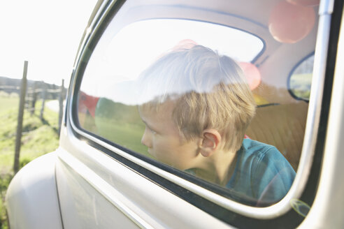Deutschland, Nordrhein-Westfalen, Köln, Junge im Auto schaut durch Fenster, Nahaufnahme - PD000315