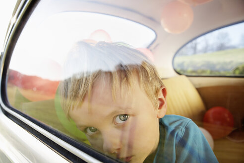 Deutschland, Nordrhein-Westfalen, Junge im Auto schaut durch Fenster - PD000326