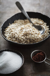 Bowls of oat flake, sugar and cacao powder on table, close up - EVG000080