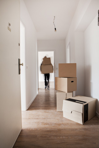 Man unloading cardboard boxes in new house stock photo