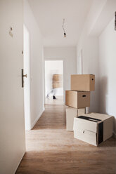 Cardboard boxes on corridor while man walking in background - FMKF000531