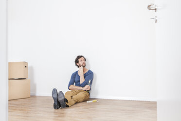 Man sitting on floor and looking away - FMKF000569