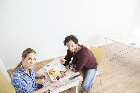 Paar beim Mittagessen in einem neuen Haus, lächelnd - FMKF000586