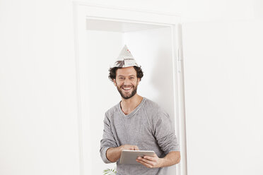 Portrait of man using digital tablet, smiling - FMKF000587