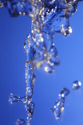 Splashing water against blue background - JTF000315