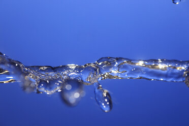 Splashing water against blue background - JTF000307