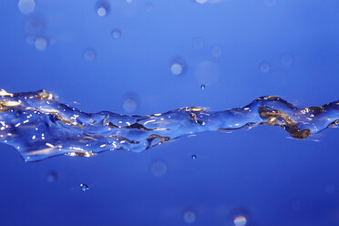 Splashing water against blue background - JTF000309