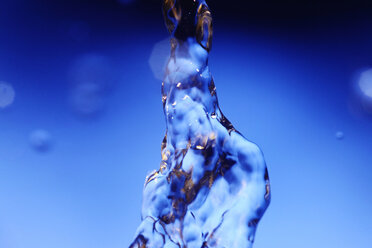 Splashing water against blue background - JTF000310