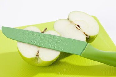 Grüner Apfel mit Messer auf Schneidebrett, Nahaufnahme - CSF017862
