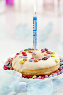 Doughnut mit beleuchteter Geburtstagskerze, Nahaufnahme - CSF017902