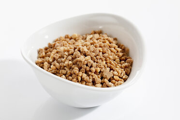 Bowl of crispy almond brittle on white background, close up - CSF017937