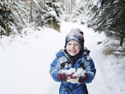 Österreich, Junge spielt mit Schnee im Wald - CW000018