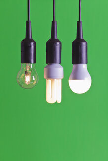 Halogen bulb and LED lamp against green background, close up - WDF001659