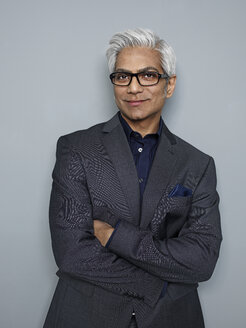 Portrait of businessman standing with arms crossed, smiling - STKF000202