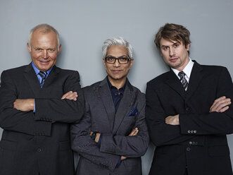 Portrait of businessmen smiling against grey background - STKF000205