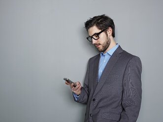 Businessman holding mobile phone - STKF000231