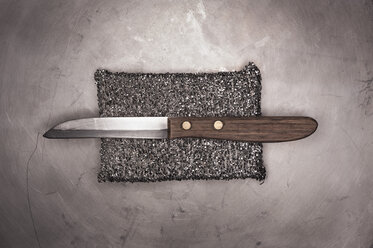 Altes Küchenmesser mit silbernem Schwamm auf Metalloberfläche - KJF000212