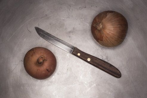 Old kitchen knife with onions on metal surface - KJF000214