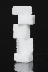 Stack of sugar cubes on black background - MUF001286