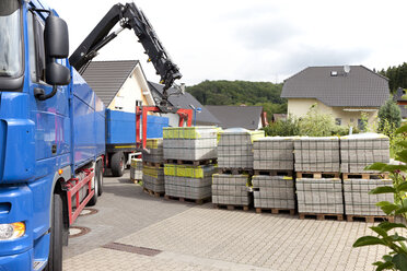 Deutschland, Rheinland-Pfalz, Lkw entlädt Stapel von Pflastersteinen - CSF018060