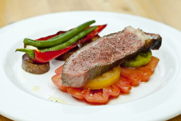 Germany, Duesseldorf, Plate of grilled beef with tomatos and paprika, close up - KVF000010