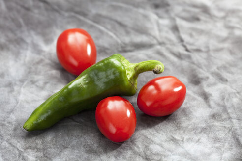 Green pepper and mini plum tomatoes on grey background, close up - CSF018161