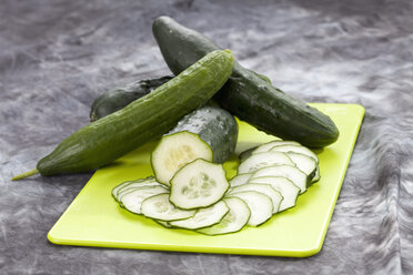 Sliced cucumber on chopping board, close up - CSF018189
