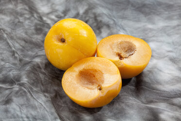 Yellow plums on grey background, close up - CSF018230