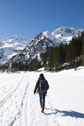 Austria, Woman hiking at Tannheim Alps in winter - UMF000607