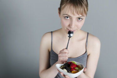 Porträt einer jungen Frau, die Joghurt mit Obstsalat isst, Nahaufnahme - ONF000066