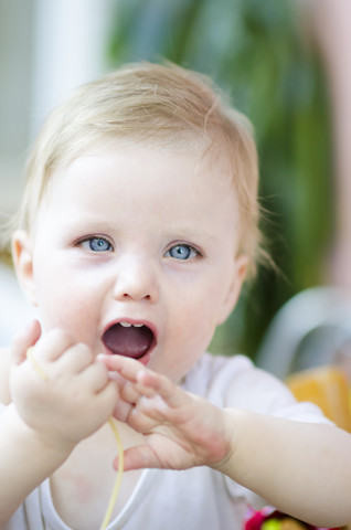 Baby-Mädchen isst Spaghetti, Nahaufnahme, lizenzfreies Stockfoto