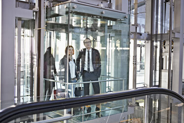 Deutschland, Köln, Junge Frau und reifer Mann in Rolltreppe am Flughafen - RHYF000288