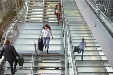 Deutschland, Köln, Menschen, die mit Gepäck auf dem Bonner Flughafen die Treppe hinauf- und hinuntergehen - RHYF000335