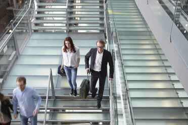 Deutschland, Köln, Menschen gehen die Treppe mit Gepäck am Flughafen hinunter - RHYF000316