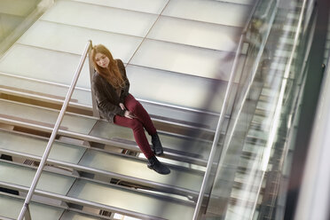 Deutschland, Köln, Jugendliches Mädchen sitzt auf Treppe - RHYF000326