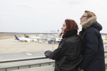 Germany, Cologne, Young woman and mature man looking at airport - RHYF000328