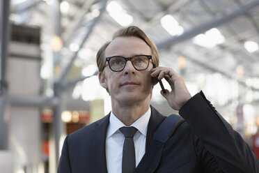 Germany, Cologne, Mature man on phone at airport - RHYF000295